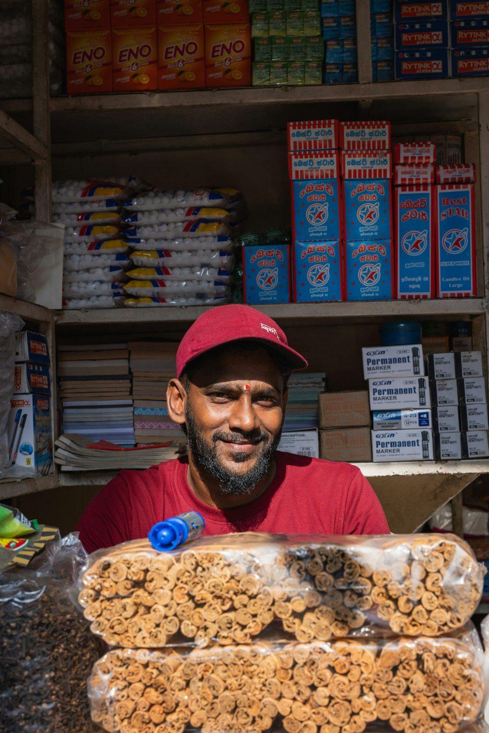A smiling shopkeeper behind the counter of his kirana store